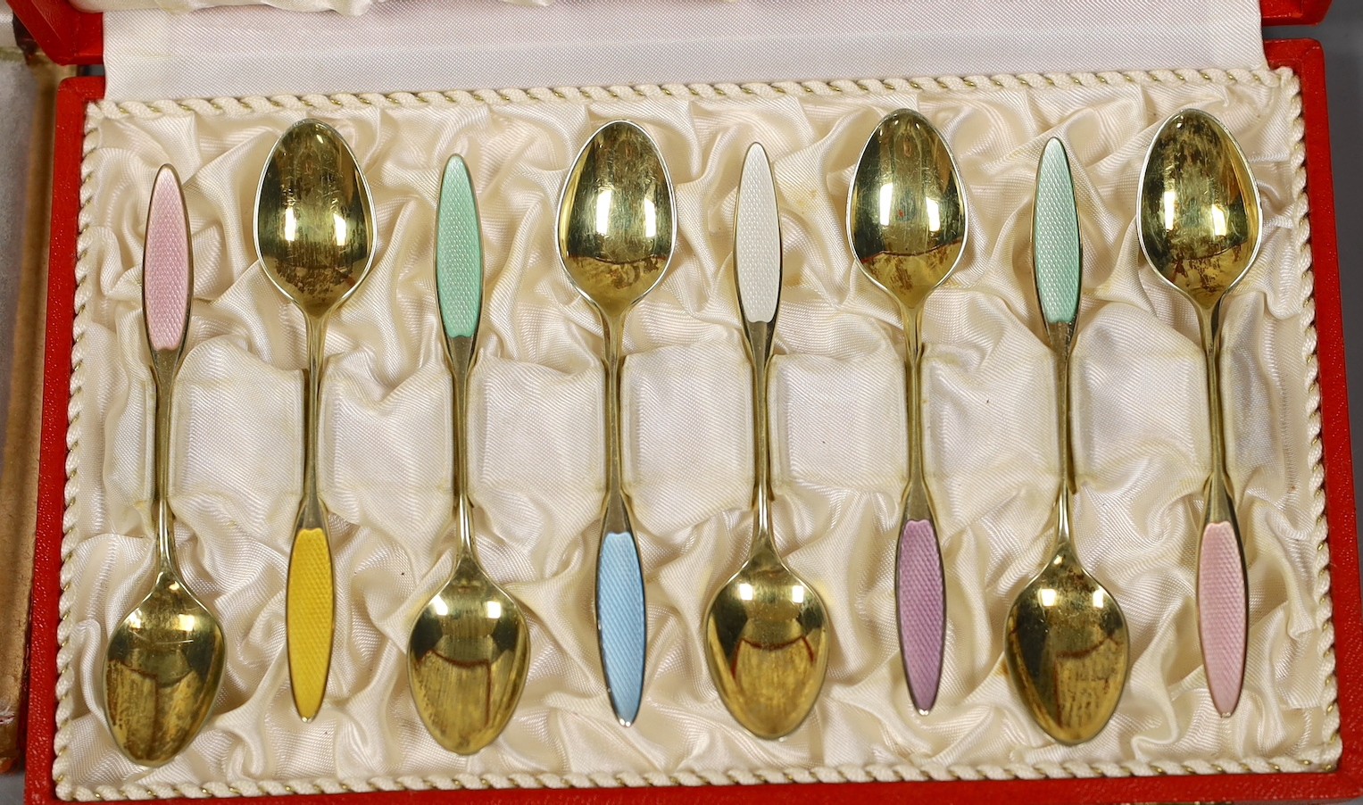 A cased set of eight Danish gilt sterling and polychrome enamelled coffee spoons and a similar cased set of six coffee spoon.